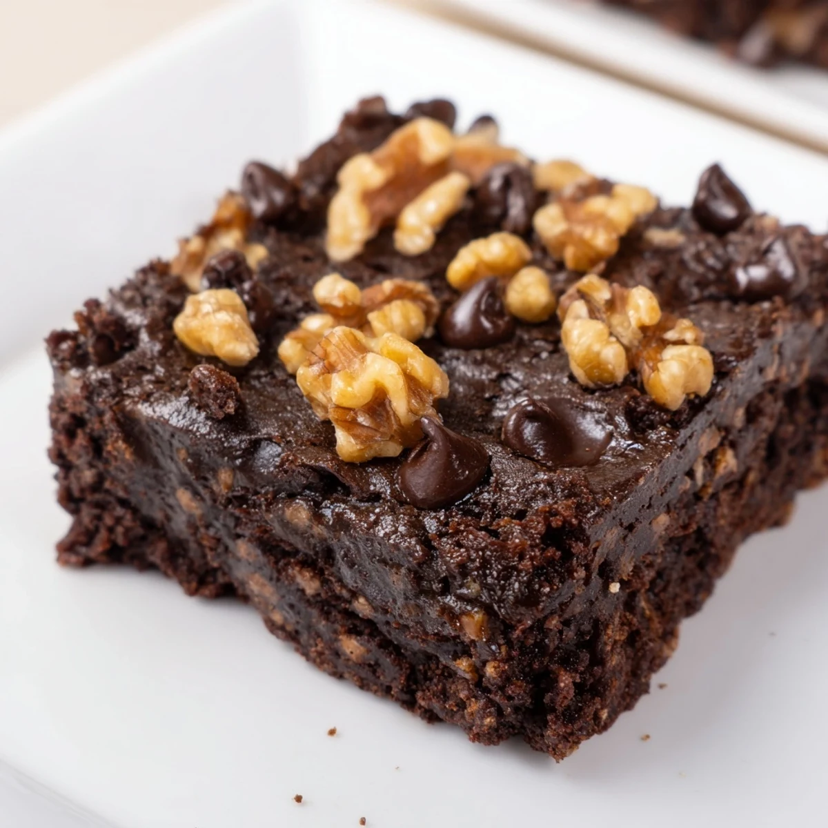 Sliced squares of Chocolate Fudge Brownies with Chopped Walnuts served on a white plate, ready to enjoy.