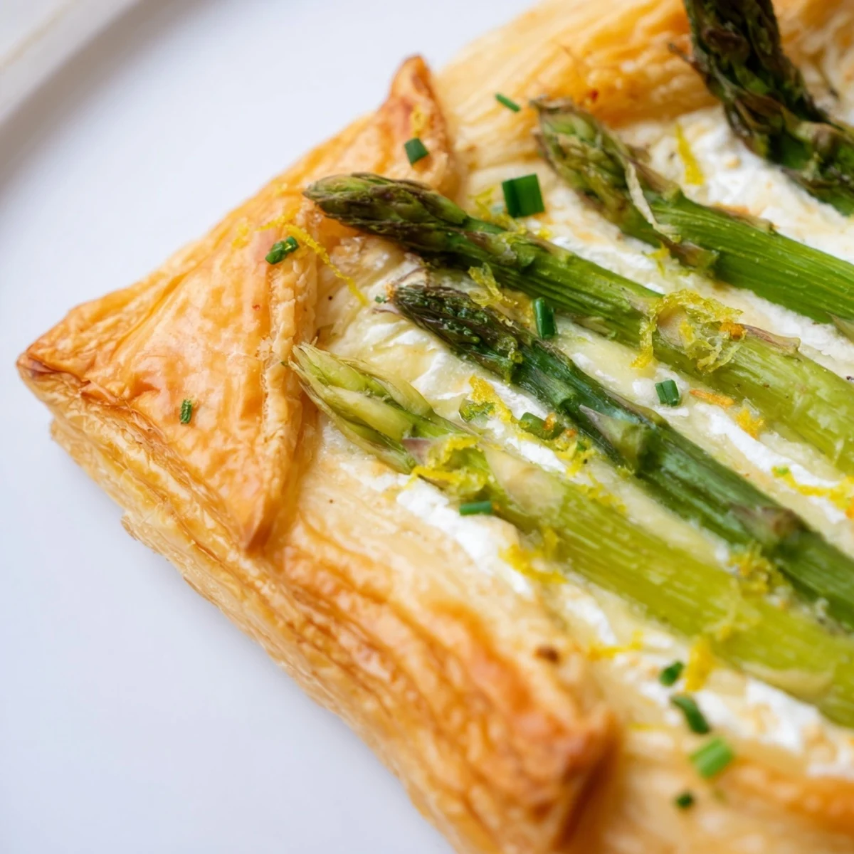 In this Green Asparagus Tart with Puff Pastry, baked asparagus and herbs crown a flaky, golden-brown crust.
