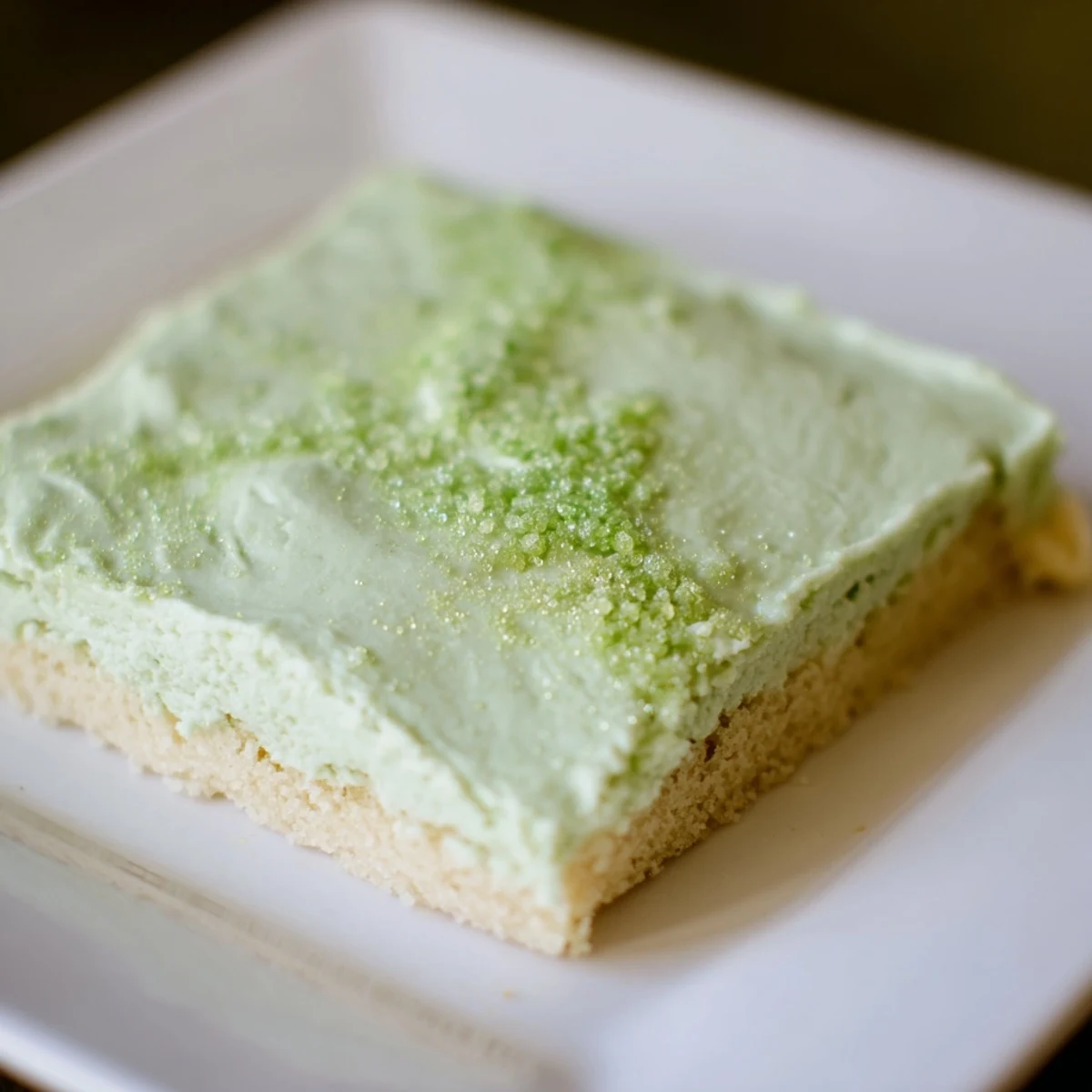 St. Patrick's Day Shamrock Cookie Bars with a generous layer of vanilla frosting and decorative green sanding sugar.
