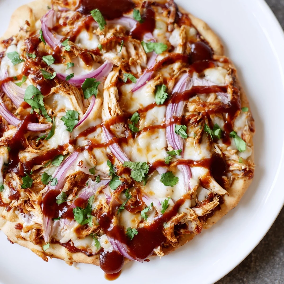 Smoky BBQ Chicken Pizza sliced into wedges, topped with fresh cilantro and ready to serve for a family dinner.