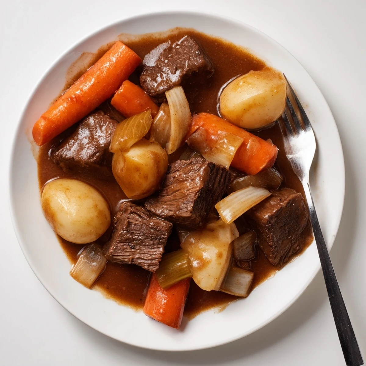 Golden Irish Beef Pot Roast with Carrots and Potatoes plated alongside crusty bread, with steam rising from the hearty meal.