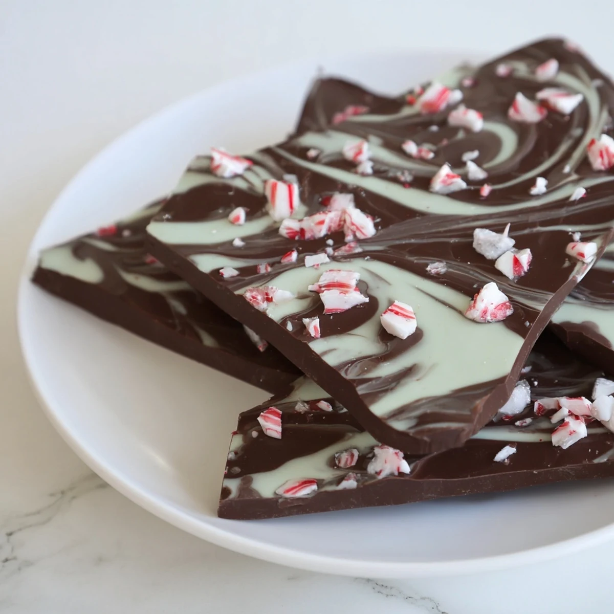 Festive Mint Chocolate Bark with White Chocolate Swirl adorned with crushed peppermint candy, ready for holiday gifting on a rustic wood board.