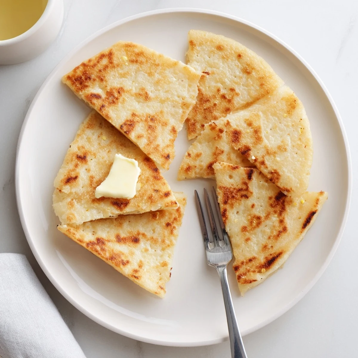 Golden-brown Irish Potato Bread Farls, pan-fried in butter and served warm with jam, ready for breakfast.