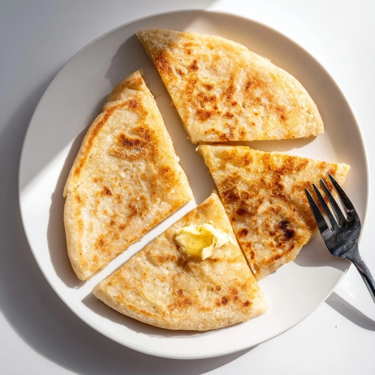 Soft, homemade Irish Potato Bread Farls, sliced to show fluffy interior, ideal alongside hearty stews.