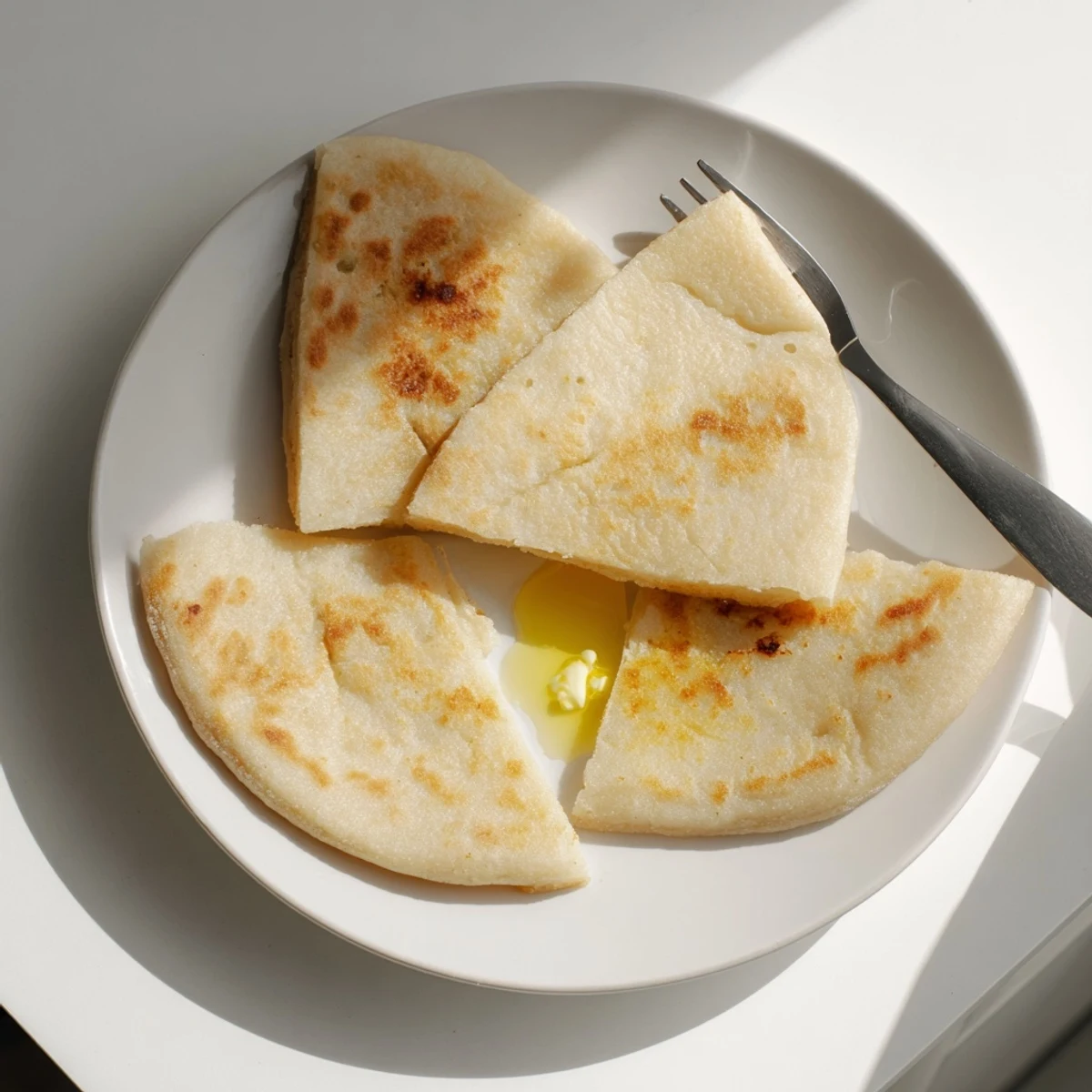 Skillet-cooked Irish Potato Bread Farls, golden and fragrant, ready to be topped with melting butter.