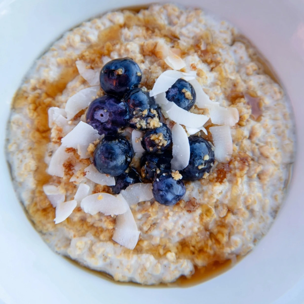 Soft morning light highlights the creamy texture of Tasty Coconut Cream Oats with strawberries.