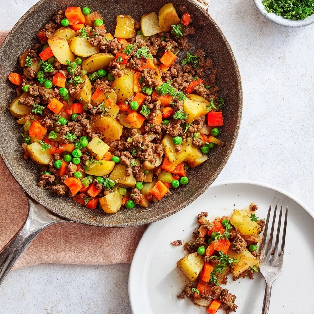 Golden one pan ground beef and potatoes skillet garnished with fresh parsley