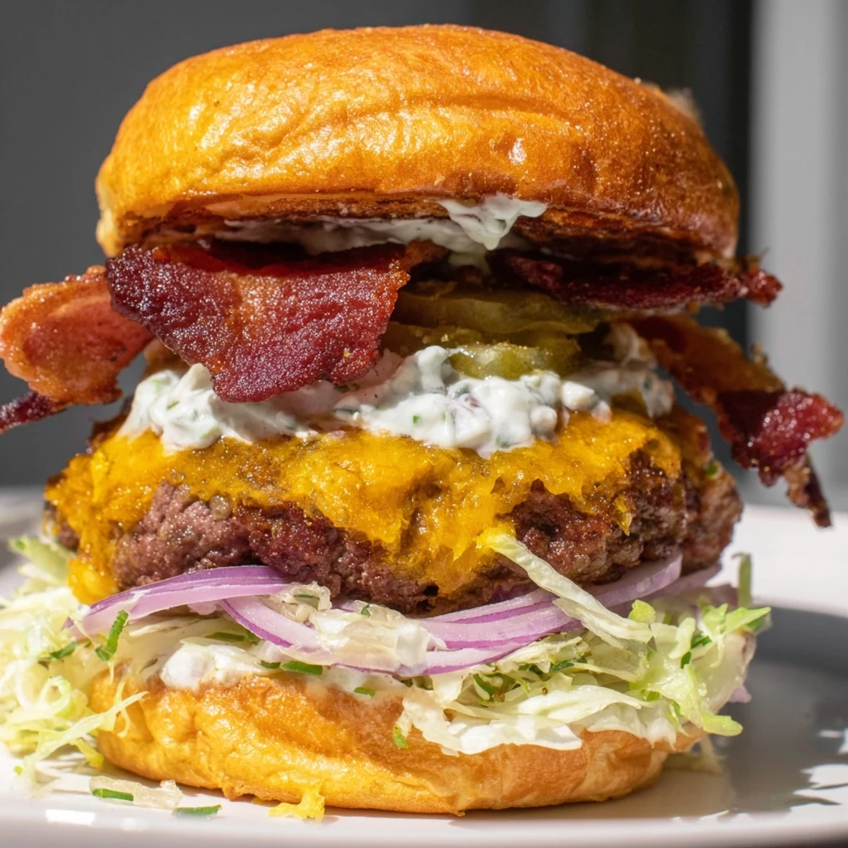 Juicy Crack Burger with melted cheddar, crispy bacon, and creamy ranch sauce on toasted brioche bun