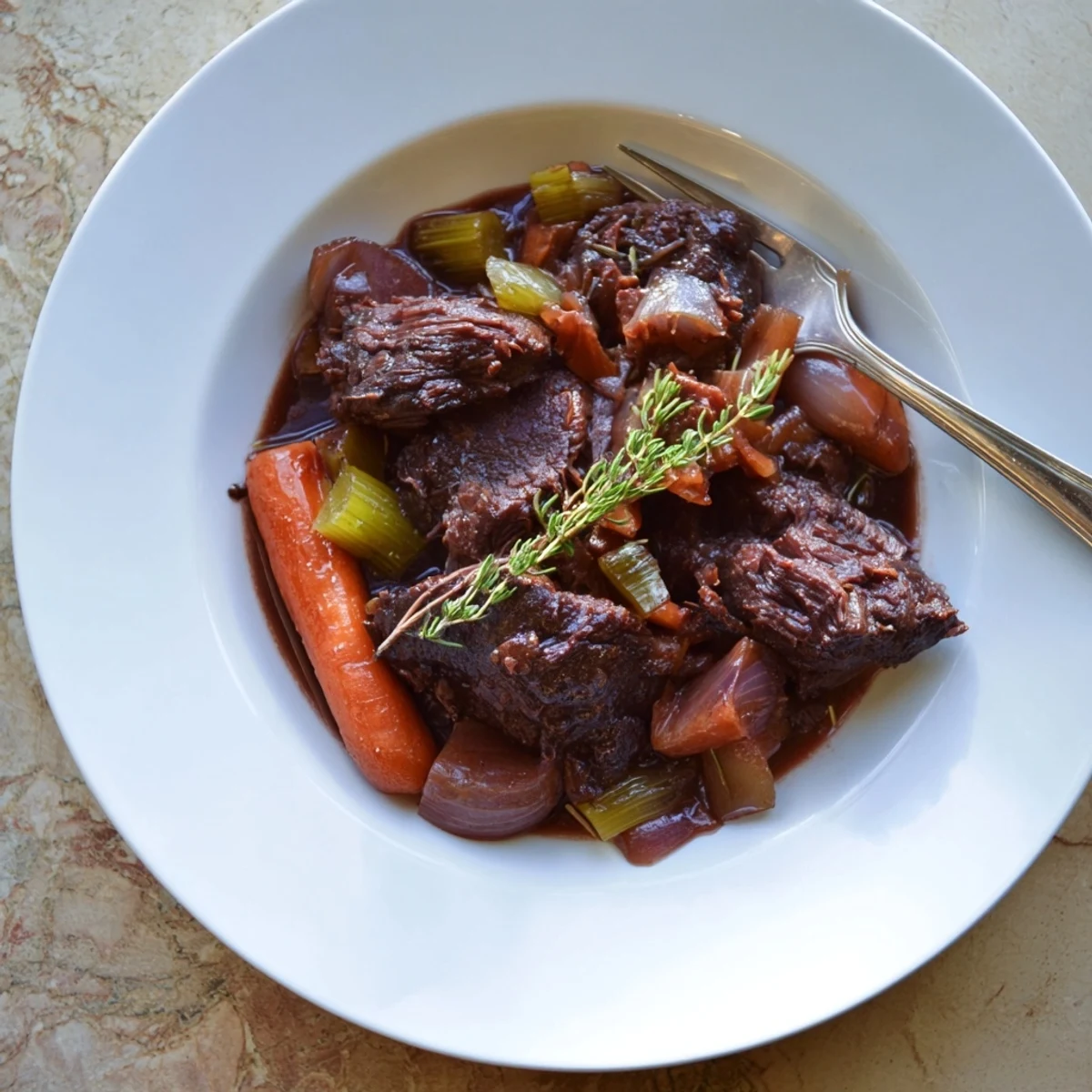 Fork-tender red grape juice braised chuck roast served with tender carrots and celery in rich, savory juices