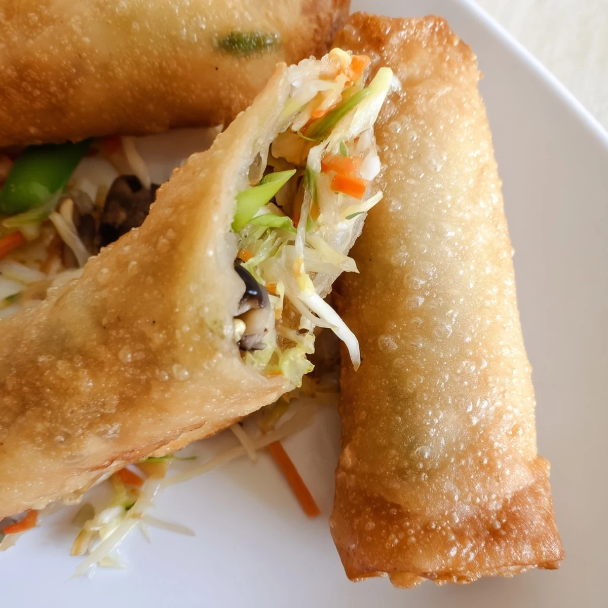 Homemade crispy spring rolls fried to perfection alongside sweet chili dipping sauce