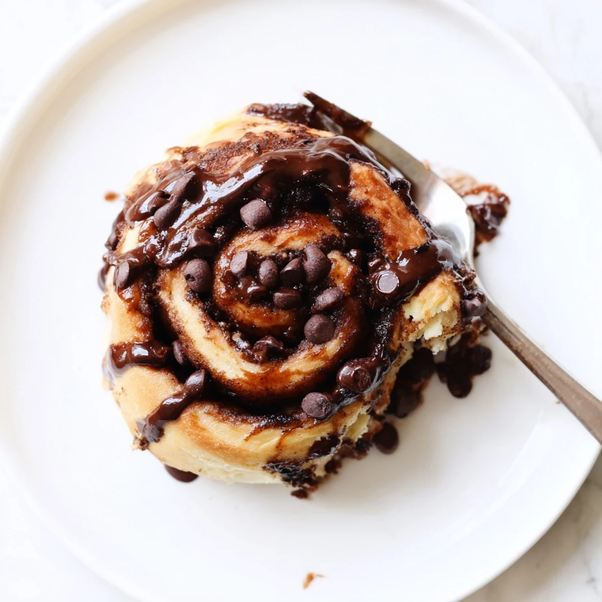 Freshly baked double chocolate cinnamon rolls with rich chocolate glaze drizzled over warm fluffy spirals