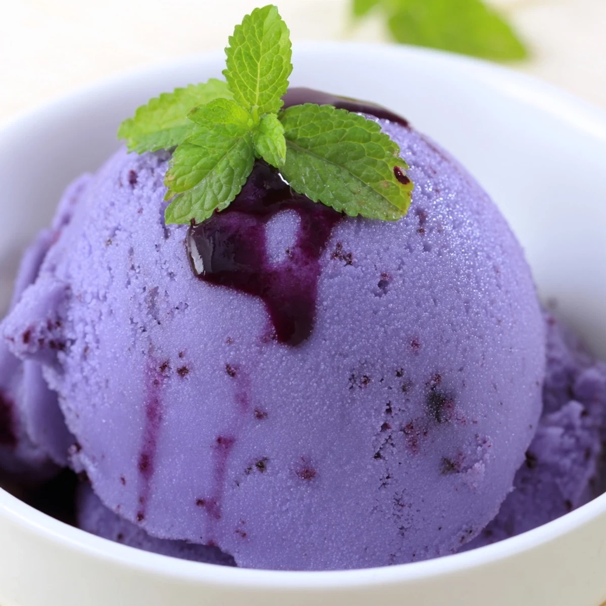 Creamy swirls of dairy-free no churn blueberry lemon sorbet with fresh lemon zest garnish