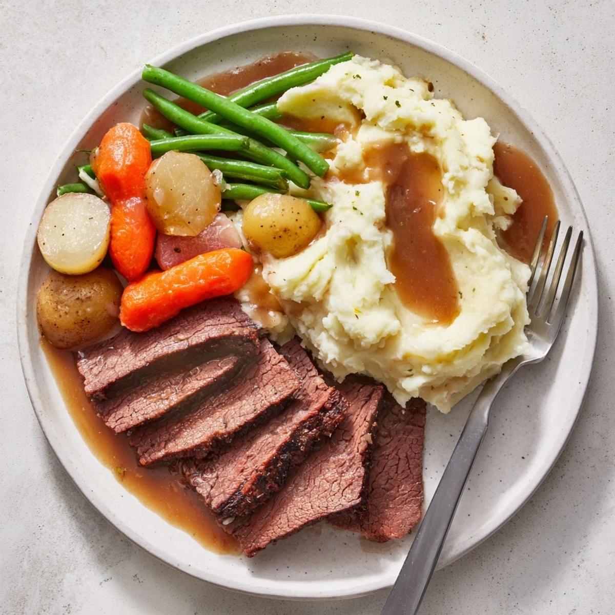 Golden brown Southern style pot roast plate with creamy mashed potatoes and tender green beans