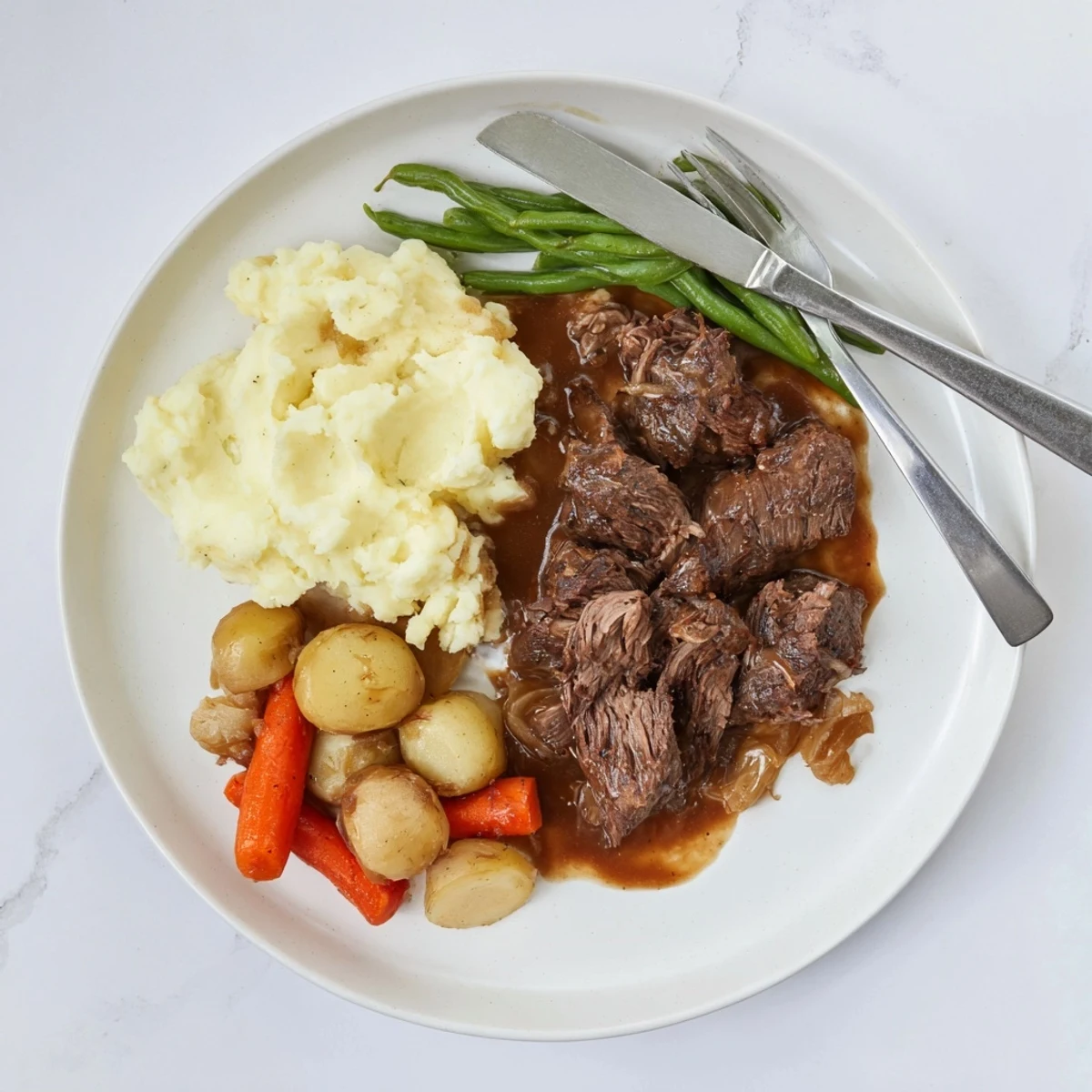 Slow-cooked Southern style pot roast served with rich gravy over fluffy mashed potatoes and vegetables