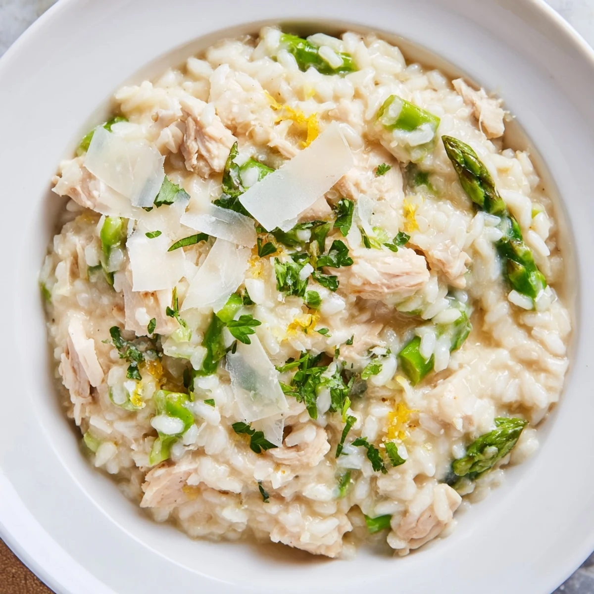 Spoonful of creamy chicken and asparagus risotto showing melted butter and parmesan cheese texture