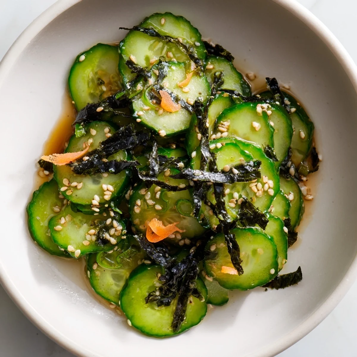 Sushi Cucumber Salad topped with crispy nori strips and sesame seeds