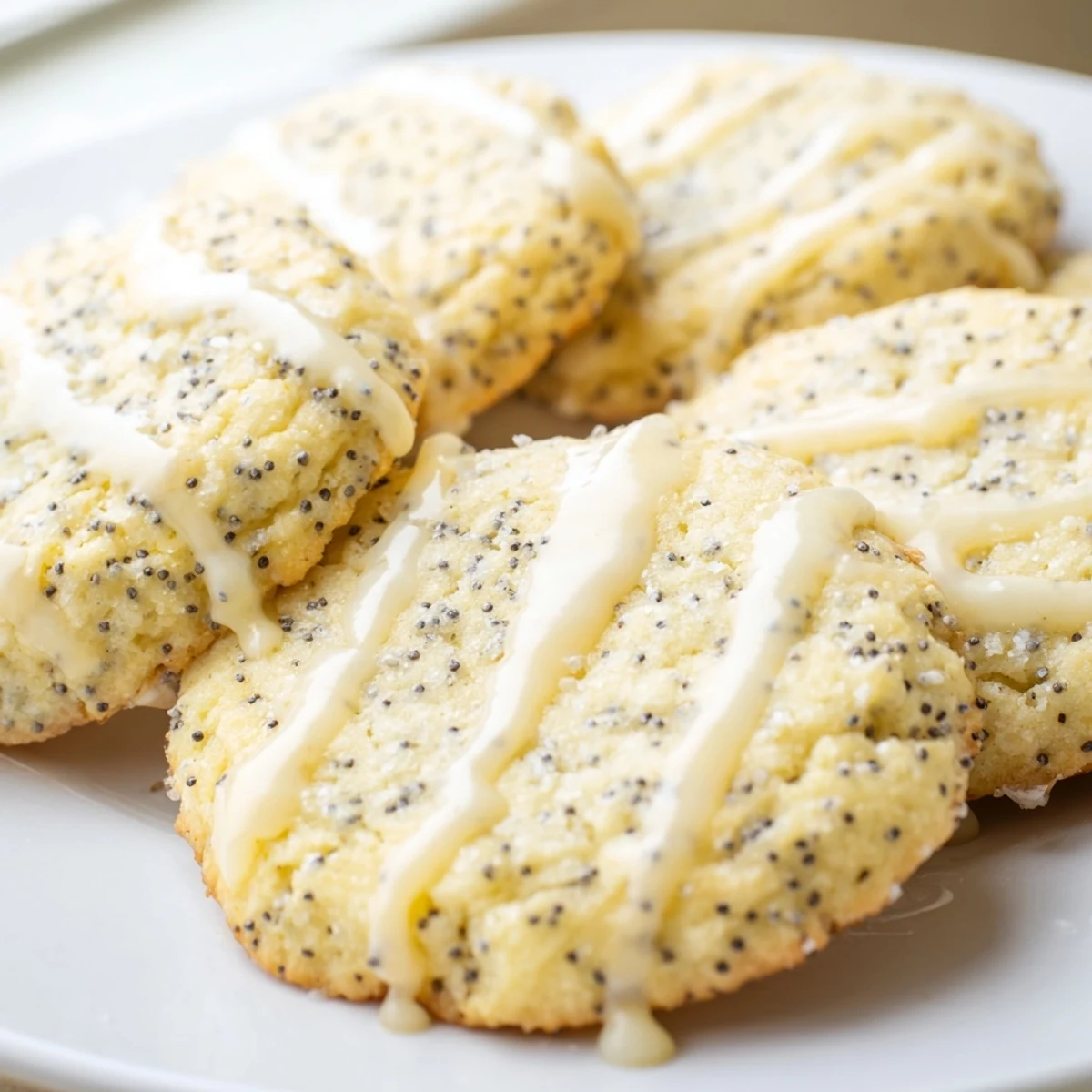 Chewy lemon poppy seed cookies drizzled with sweet citrus glaze stacked on cooling rack