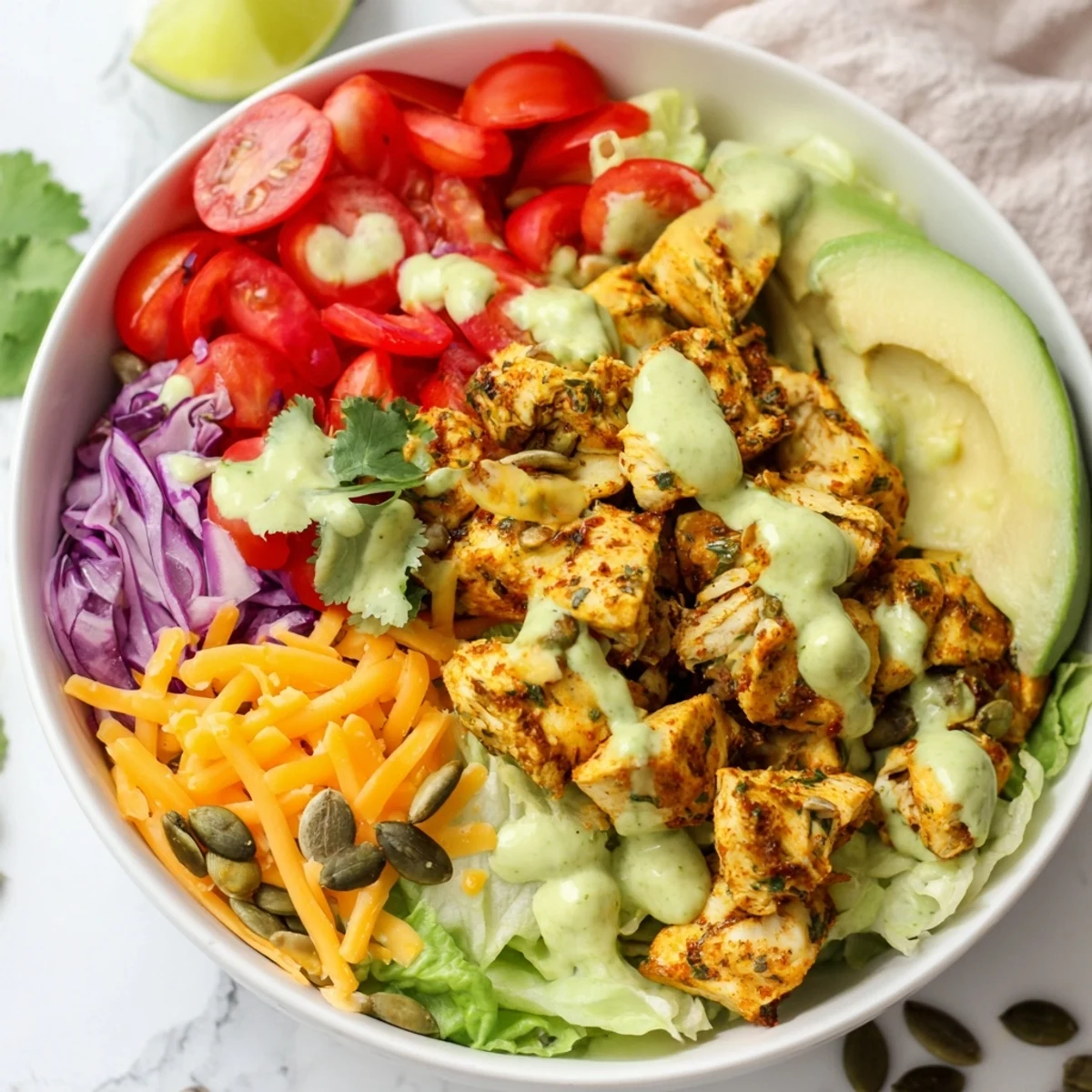 Keto bowls featuring crisp lettuce, grilled chicken, and rich avocado dressing drizzled on top