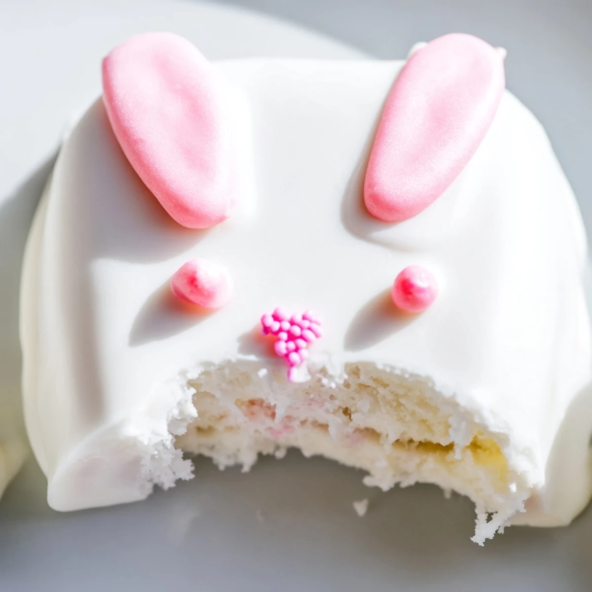 Festive Easter bunny cakesicles with smooth white chocolate coating and playful candy decorations