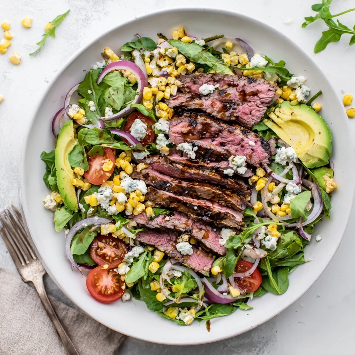 Juicy grilled flank steak and crumbled Gorgonzola over mixed greens in this balsamic steak Gorgonzola salad with grilled corn, drizzled with vinaigrette