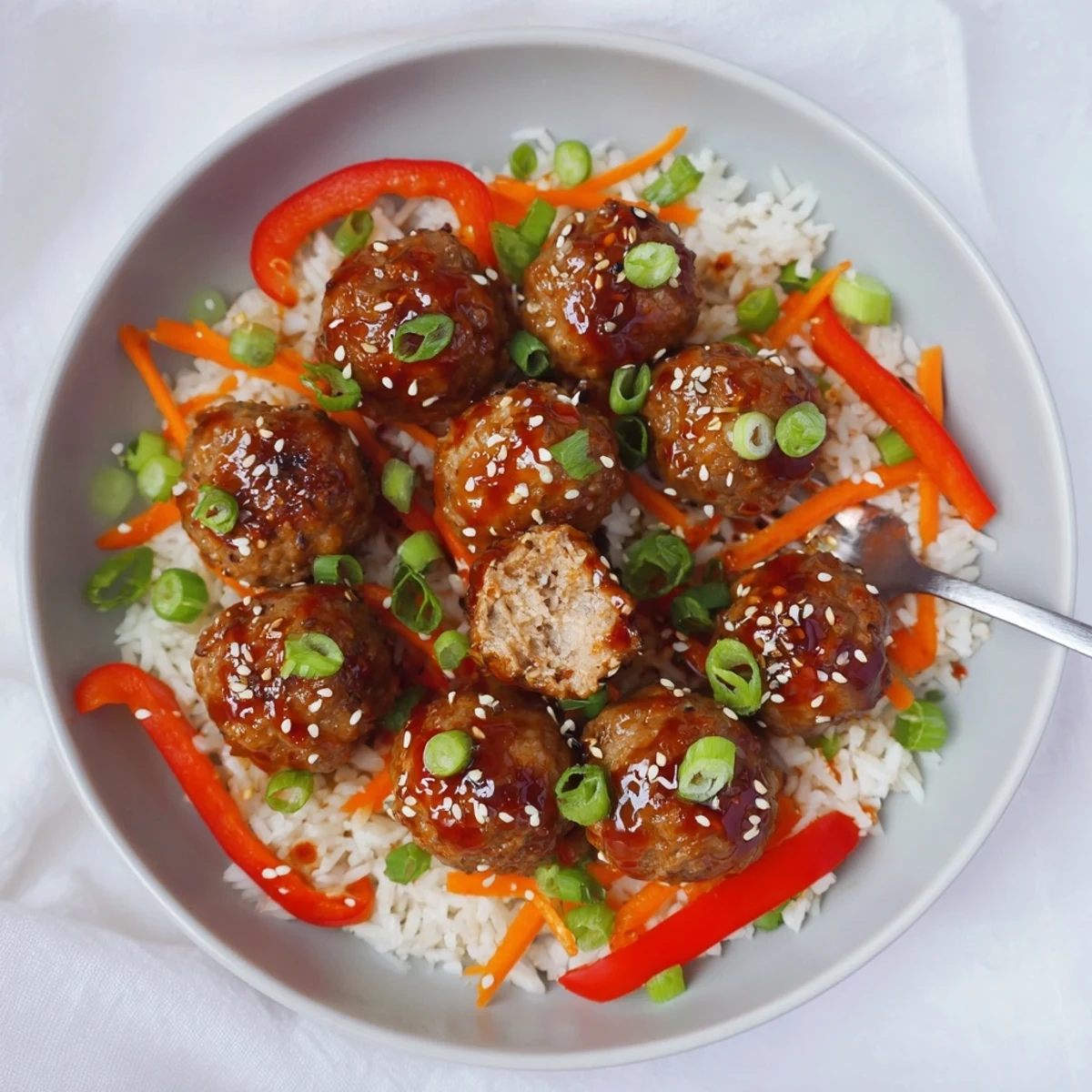 Bite-sized Hello Fresh Firecracker Meatballs topped with sesame seeds and scallion garnish