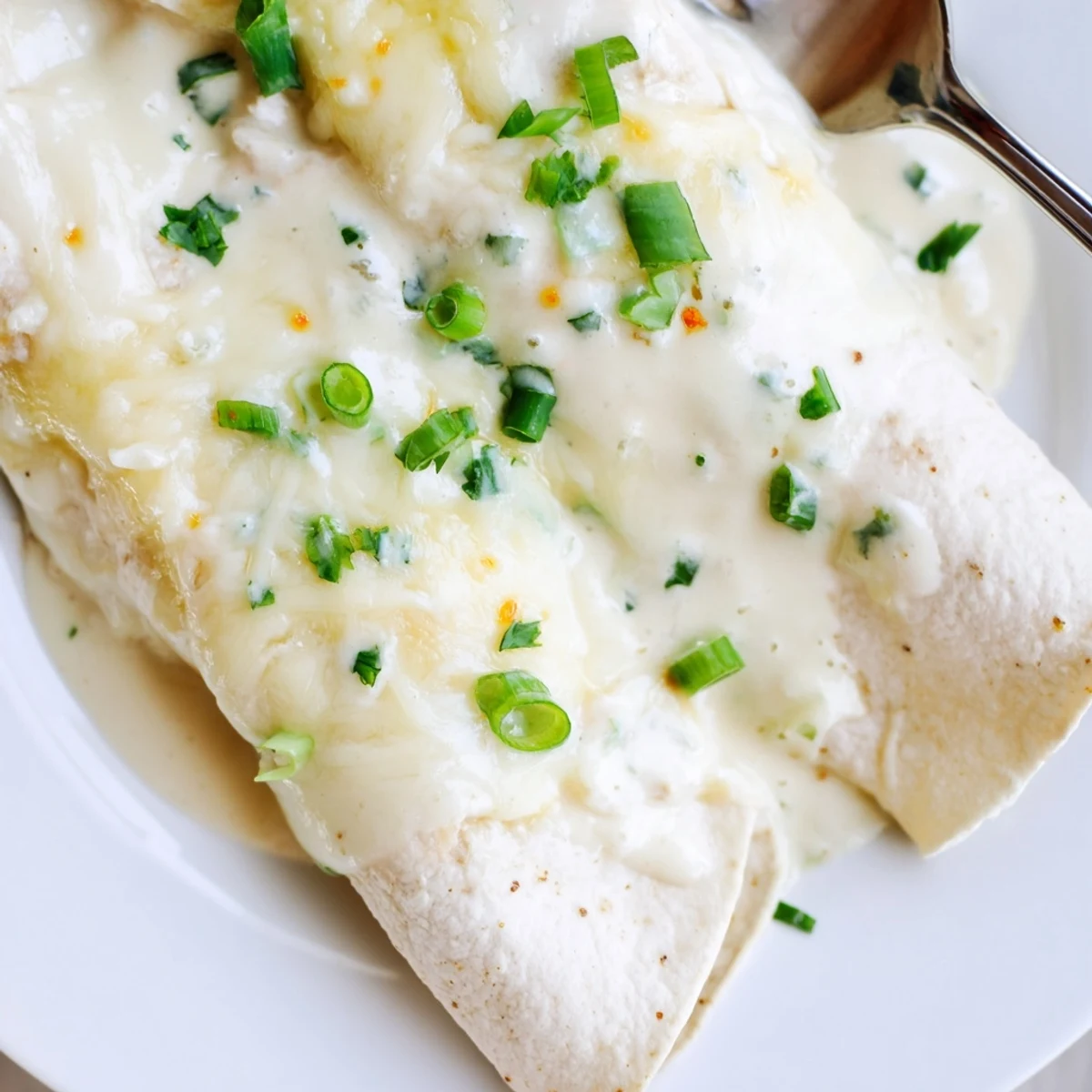 Creamy White Chicken Enchiladas steaming with melted Monterey Jack, cilantro sprinkled.  