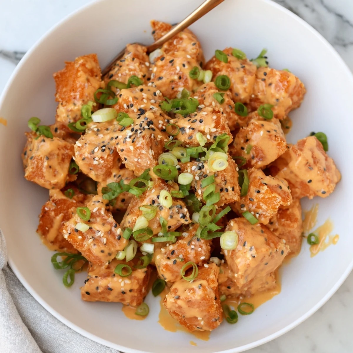Pan-fried Bang Bang Salmon Bites glistening with sauce, served over jasmine rice