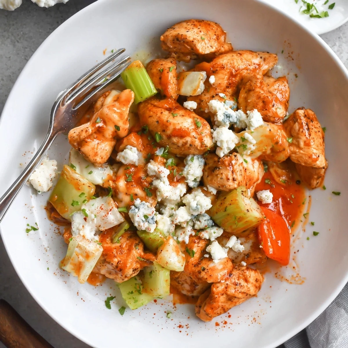 Keto Buffalo Chicken Skillet with bite-sized chicken, spicy sauce, bright parsley garnish