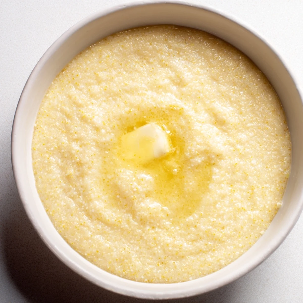 Thick smooth maize porridge breakfast bowl sprinkled with cinnamon and sliced bananas for a comforting morning meal