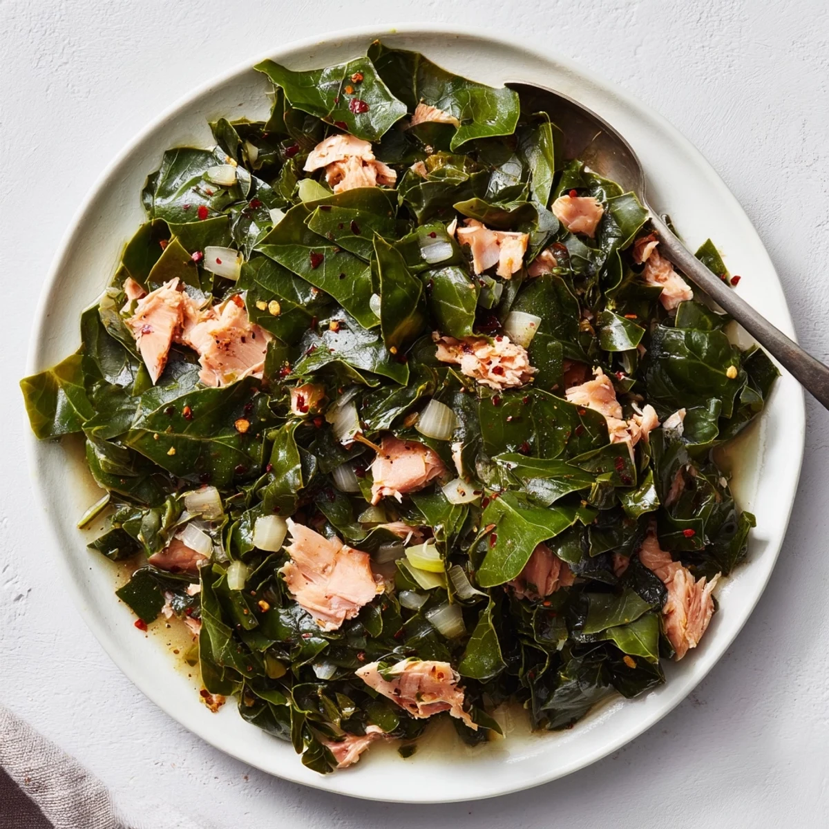 Hearty Southern collard greens bowl featuring wilted vibrant leaves seasoned with garlic and onion