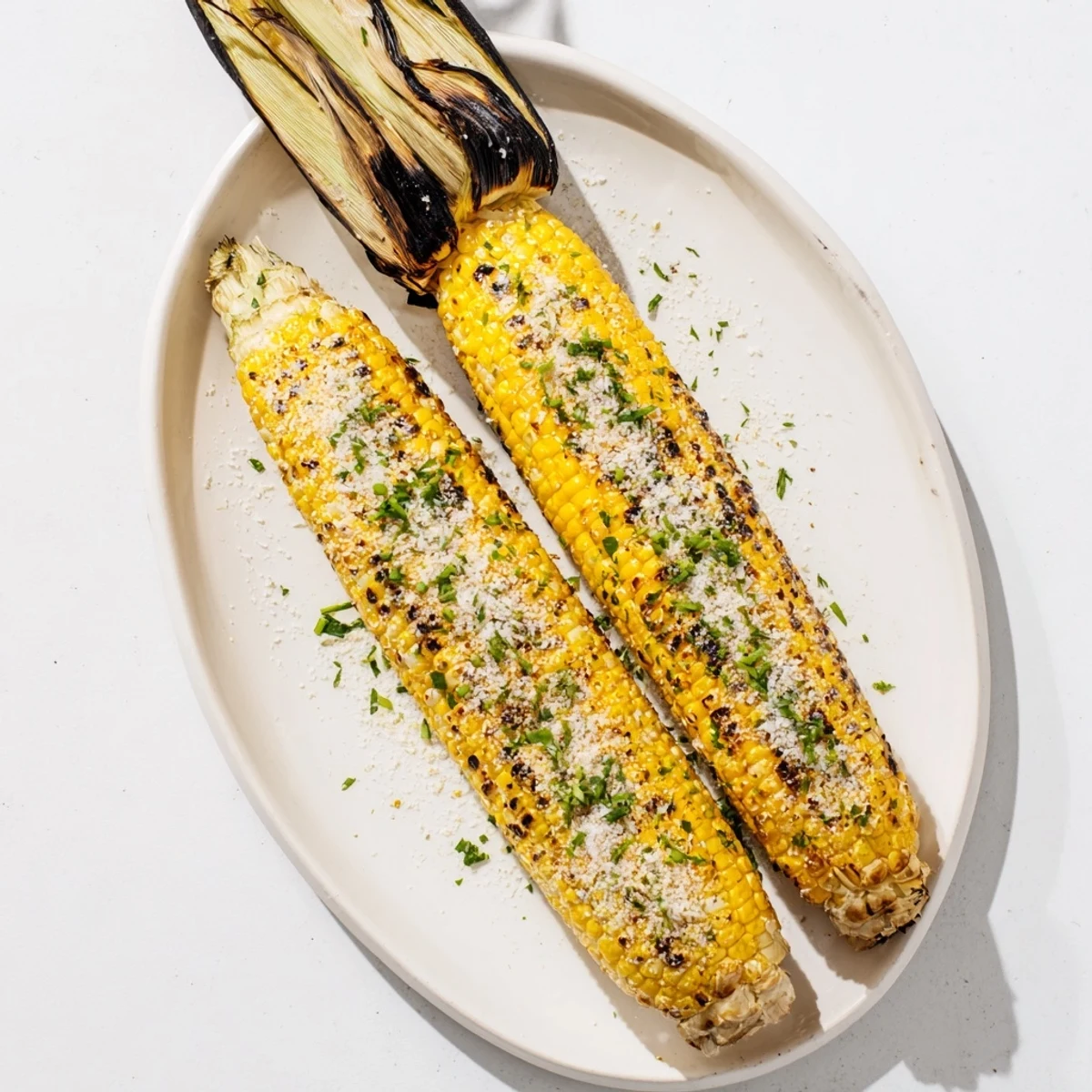 Charred sweet corn ears sprinkled with savory ranch parmesan and fresh chopped herbs