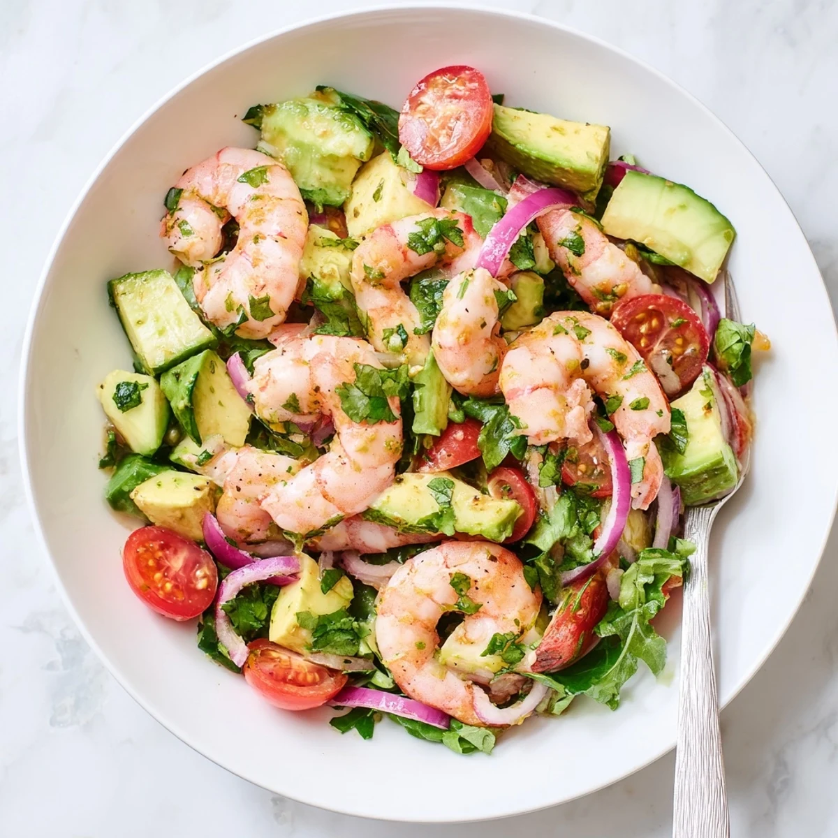 Elegant shrimp avocado salad recipe plated with succulent seafood, ripe avocado, fresh herbs, and a light honey lime vinaigrette for a healthy gluten-free lunch