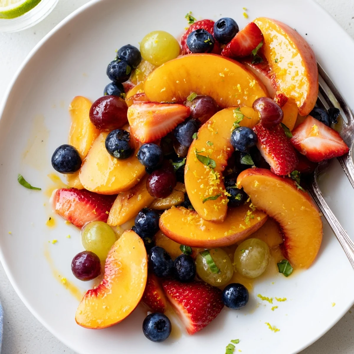 Honey Lime Basil Peach Fruit Salad glistening with lime, basil, and honey dressing