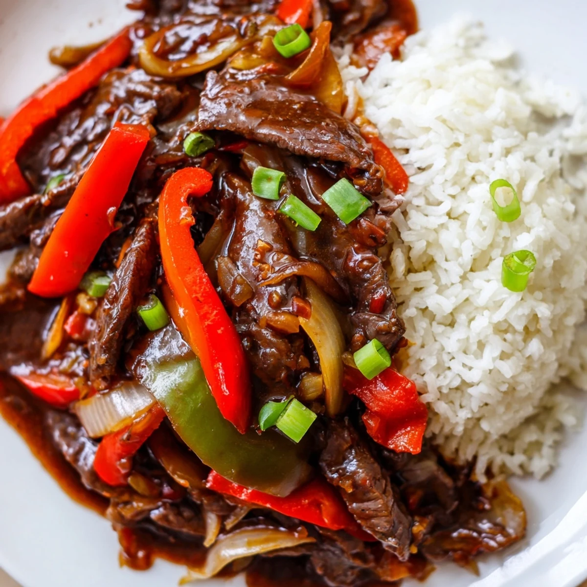 Slow Cooker Pepper Steak in glossy thickened sauce served hot alongside fluffy steamed white rice