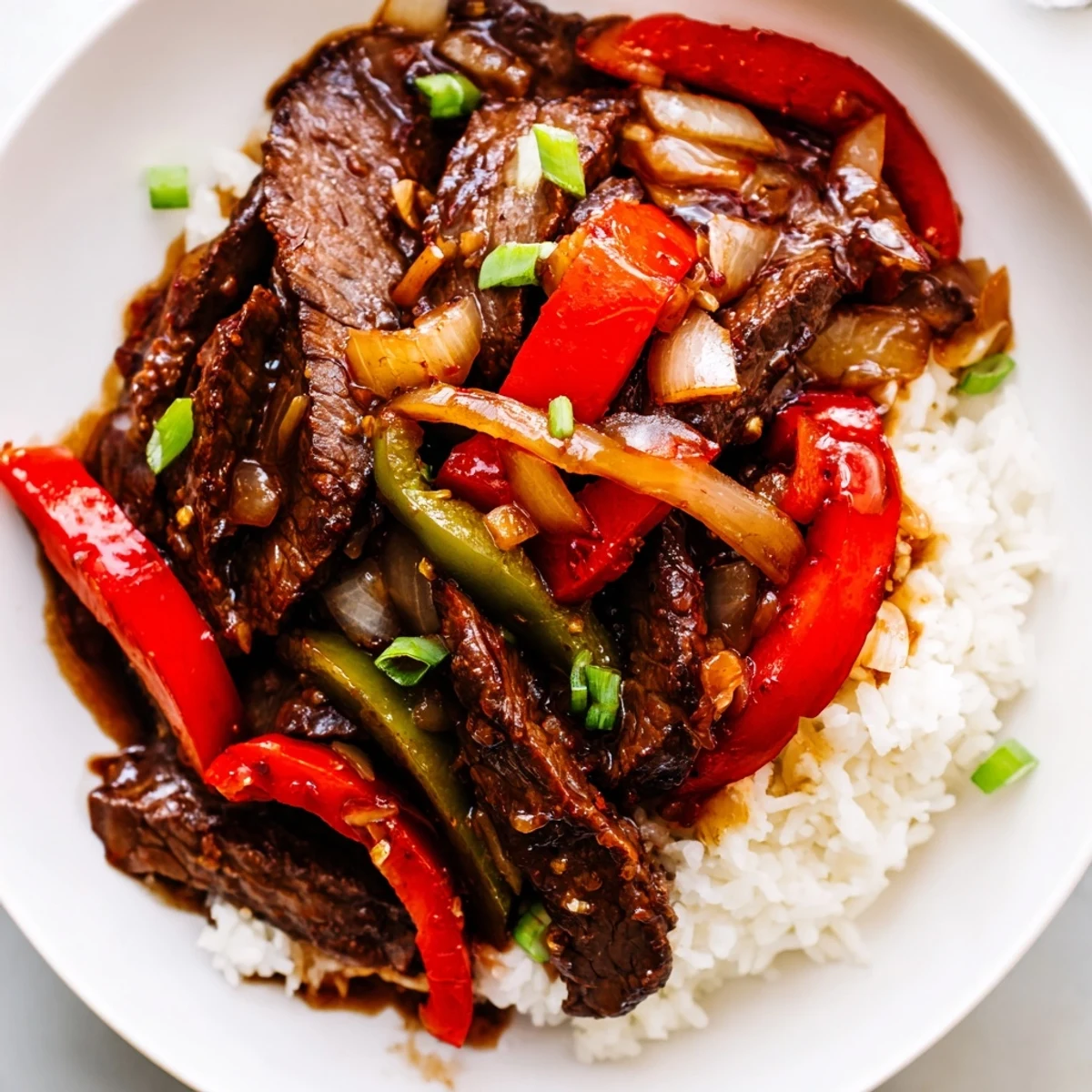 Juicy Slow Cooker Pepper Steak smothered in rich savory sauce with sliced onions and peppers