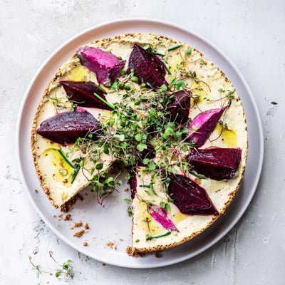 Golden-crusted savoury cheesecake served alongside caramelized beetroot wedges and microgreens