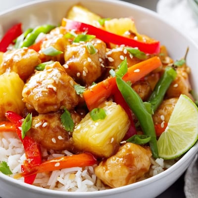 Colorful pineapple chicken rice bowl with tender glazed chicken crisp bell pepper and juicy pineapple chunks